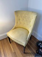 Front view showing yellow accent chair, tufted back, stains on seat and back