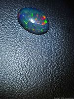 Top view of the oval Ethiopian black opal showing multicolored play-of-color