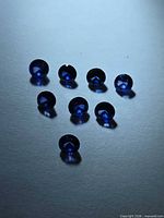 Eight round royal blue sapphires arranged on neutral background