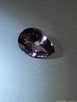 Pear-cut faceted ametrine side view showing colour zoning