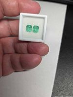 Pair of rectangular emeralds in display box, front view