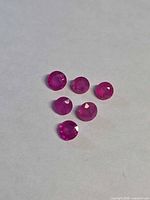 Six round rubies on light background