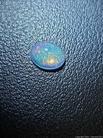 Top view of oval Ethiopian opal with multicolour pinfire pattern