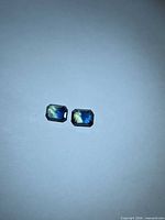 Pair of rectangular blue-yellow sapphires on white background