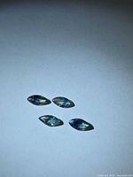 Four marquise-cut bi-colored sapphires on neutral background