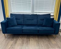 Front view of blue three-seat sofa with pillows