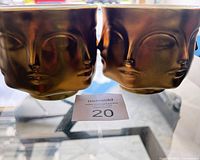 Front view showing pair of gold Muse face vases