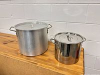 Two stock pots with lids side by side