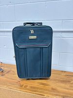 Front view of navy American Tourister suitcase