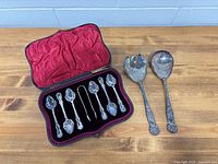 Full lot showing open case with 8 spoons and tong plus two large serving utensils