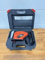 Open carry case showing jigsaw, cord, accessory bag, manual