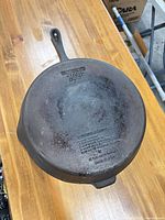 Underside of cast iron skillet showing Wagner Ware branding and overall wear