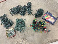 Overview of six loose string lights, boxed LED set and tin of spare bulbs