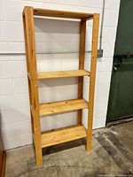 Full view of pine shelving unit against wall