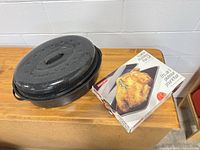 Closed oval speckled roasting pan beside boxed Roscan 3-piece pan set