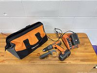 Complete RIDGID drill kit showing drill, battery, charger, handle and bag