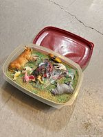 Overall view of bin with lid open showing filler and animal figurines