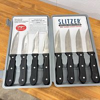 Open storage case displaying eight steak knives