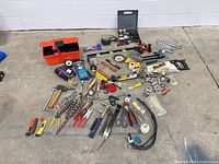 overview of entire lot spread on floor showing toolbox, hand tools, drill bits, levels, sockets, wrenches