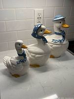All three ceramic goose cookie jars displayed together