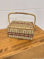 Closed wicker sewing basket on table