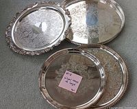 Four silver-plated trays grouped to show fronts and sizes