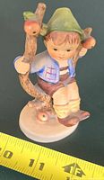 Boy in Apple Tree Hummel figurine with tape for scale