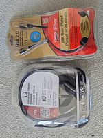 Sealed Staples USB cable and sealed stereo headset in clamshells