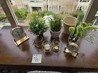 Group shot of both clocks, three candle holders, three potted faux plants