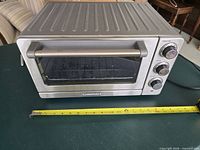 Angled view of toaster oven showing size with tape measure