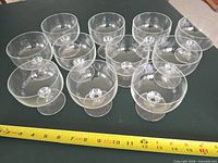 All 11 glass dessert bowls arranged, tape measure for scale