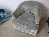 Front view of grey velvet barrel chair showing overall form and seat cushion