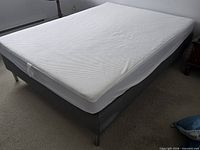 Full view of grey bed base with white mattress