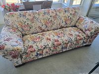 Front view of full sofa showing floral upholstery and overall style