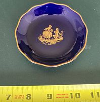 Top view Limoges Castel cobalt dish showing cobalt glaze, gold couple motif, scale tape