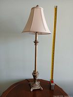 Tall column lamp beside tape measure showing height