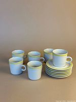 Front view showing all six mugs and stacked plates
