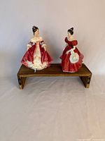 Both Royal Doulton figurines on display stand