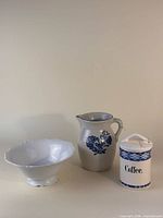 Group view of porcelain bowl, stoneware pitcher, ceramic coffee canister
