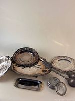 Group view of all silver-plated items and glass coasters