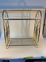 Front view of brass blanket rack showing overall form with two rails and bottom shelf