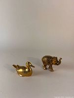 duck and elephant figurines side by side
