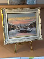 Frontal view of framed winter canal painting