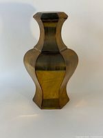 Full view of faceted brass urn, lid on