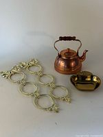 Group view of copper teapot, brass apple dish, and two gold-tone picture strip frames