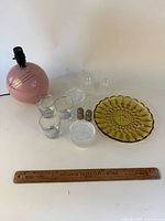All items laid out: pink lamp, amber plate, three tumblers, shakers, coasters