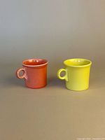 Front view of both orange and yellow Fiesta mugs