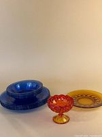 Stack of cobalt blue plates and bowls, amberina compote, amber plate