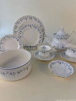 Group showing dinner and side plates, teacup, saucer, teapot, gravy boat, ramekin, shell dish