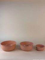 Front view of all three nested pink melamine bowls